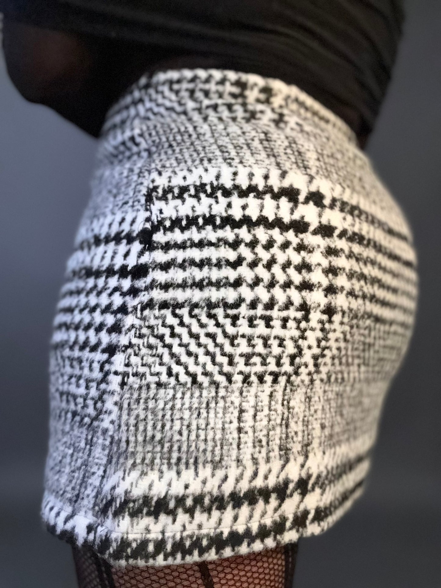 Zoomed in detail view of women's elevated casual black and white plaid mini skirt, showcasing fabric texture and pattern for a stylish, timeless look.