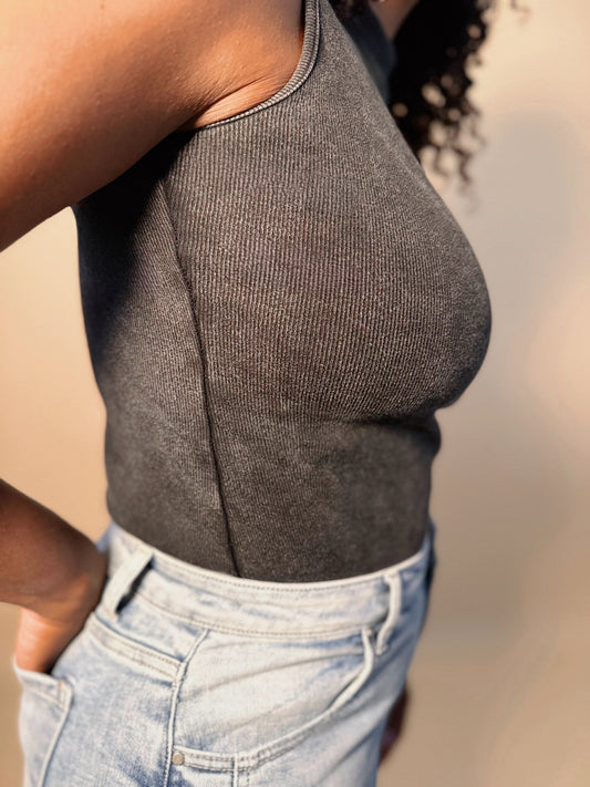 Side detail view of Women's Elevated Casual black Mineral Washed Mock Neck Bodysuit top, highlighting its textured finish, sleek fit, and modern design.
