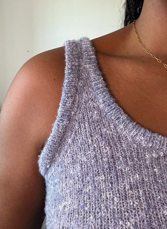 Detailed view of women's sleeveless solid knit top, showcasing the soft fabric, fine stitching, and elegant texture for a stylish and comfortable fit.