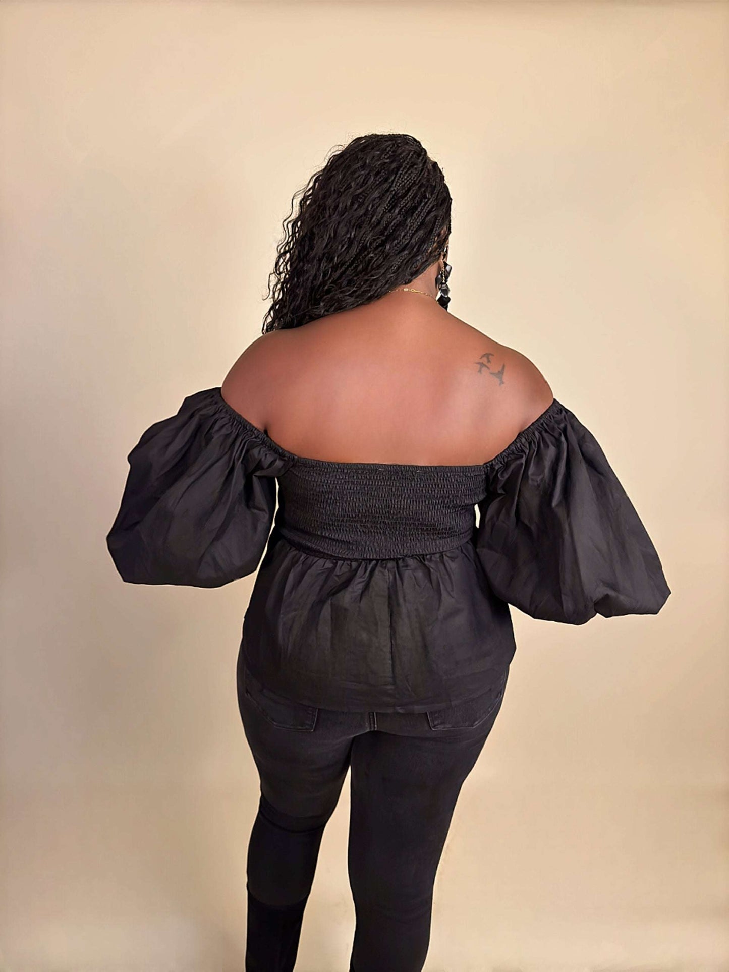 Back view of black Womens Elevated Casual Sweetheart Puff Sleeve Peplum Top, showcasing elegant back detailing, statement puff sleeves, and a structured peplum silhouette for a chic, feminine look.