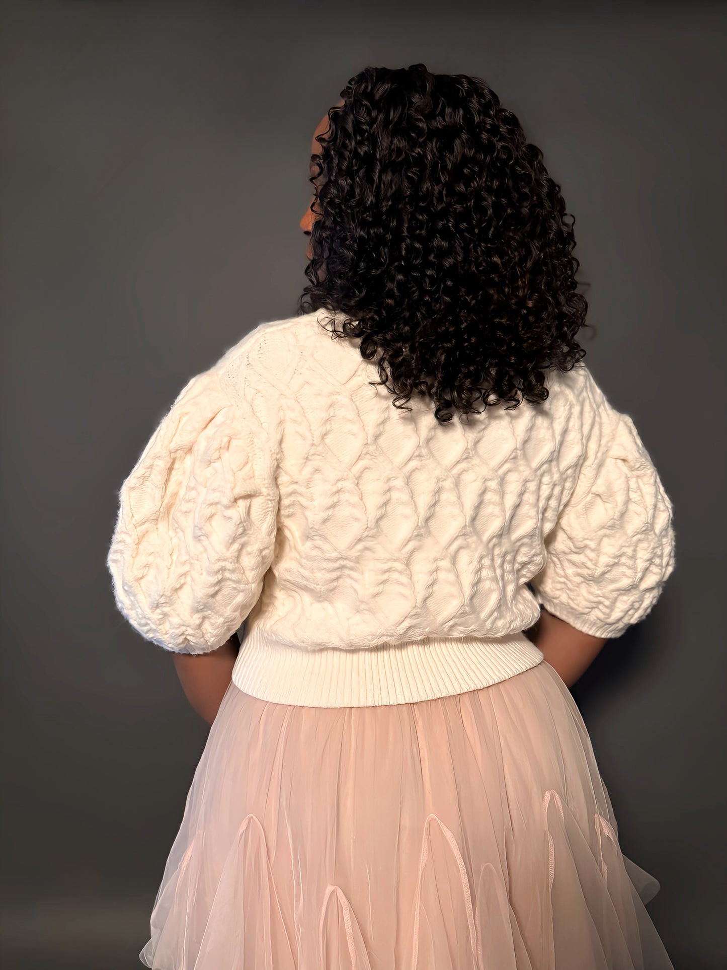 Back view of a short-sleeve puff-sleeve sweater, showcasing the elegant design and structured puff sleeves.