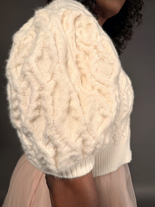 Side view of a short-sleeve puff-sleeve sweater, highlighting the intricate sleeve detail and soft fabric texture.