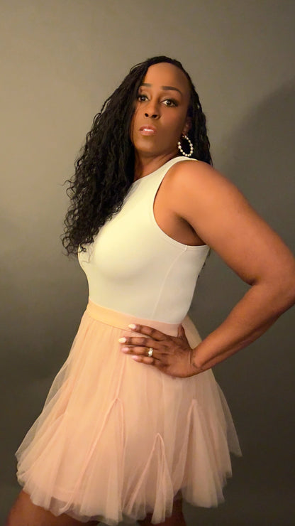 Side view of the white bone sleeveless bodysuit with a boat neckline, showcasing its flattering cut and minimalist high-end style for spring layering. Paired with the Tulle Godet Detail Mini Skirt