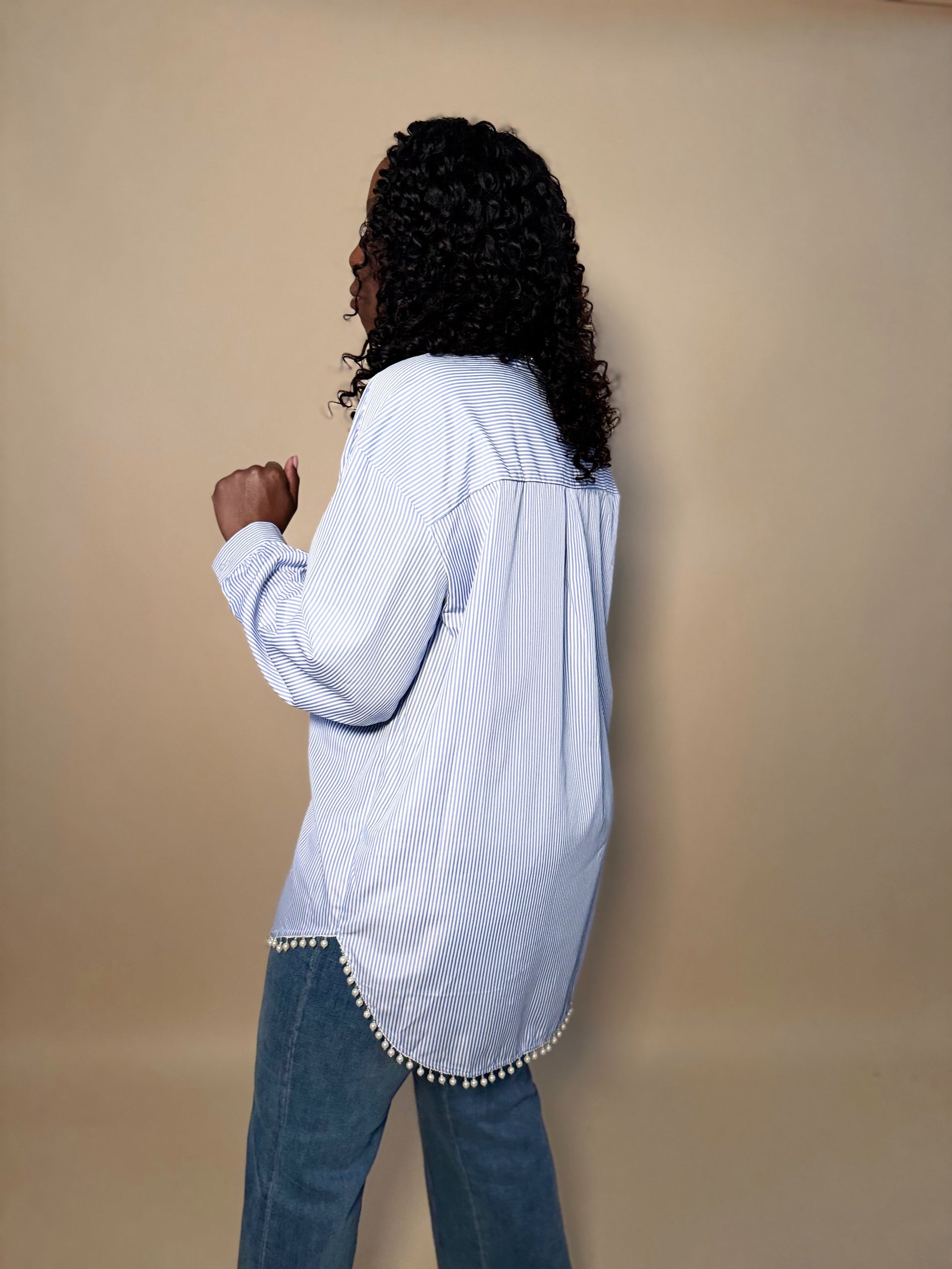 Side view of faux pearl trimmed oversized button-down shirt on model