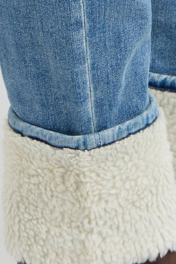 Close-up of blue jeans with white sherpa lining on a white background