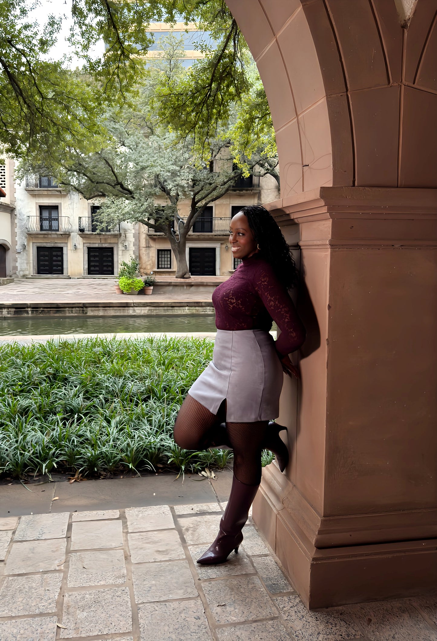 Side view of gray women's elevated casual faux suede mini skirt with slit, highlighting its sleek design, soft texture, and flattering silhouette.