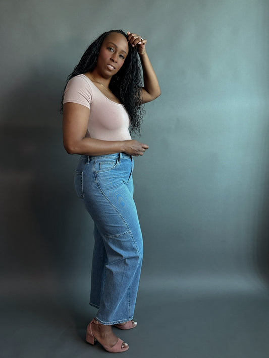 Side view of a woman wearing stylish women’s barrel jeans with a finished hem showcasing a barrel jeans outfit paired with a bodysuit, perfect for everyday elevated casual wear
