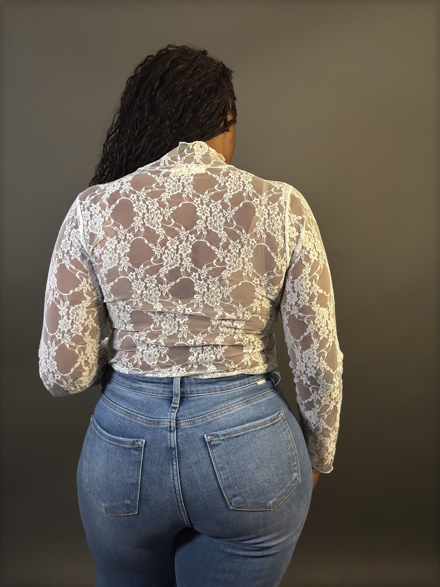 Back view of women's elevated casual white lace mock neck sheer lace top, showcasing intricate lace detailing and a stylish, fitted silhouette.